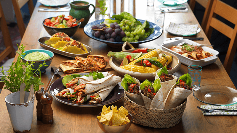 buffet fajitas burritos quesadillas tacos enchiladas salsa nachips served on a wooden table