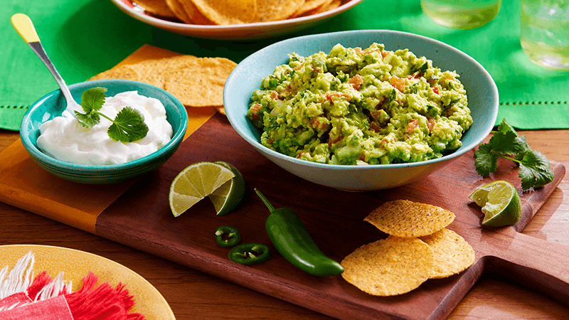 guacamole chips served on wooden board